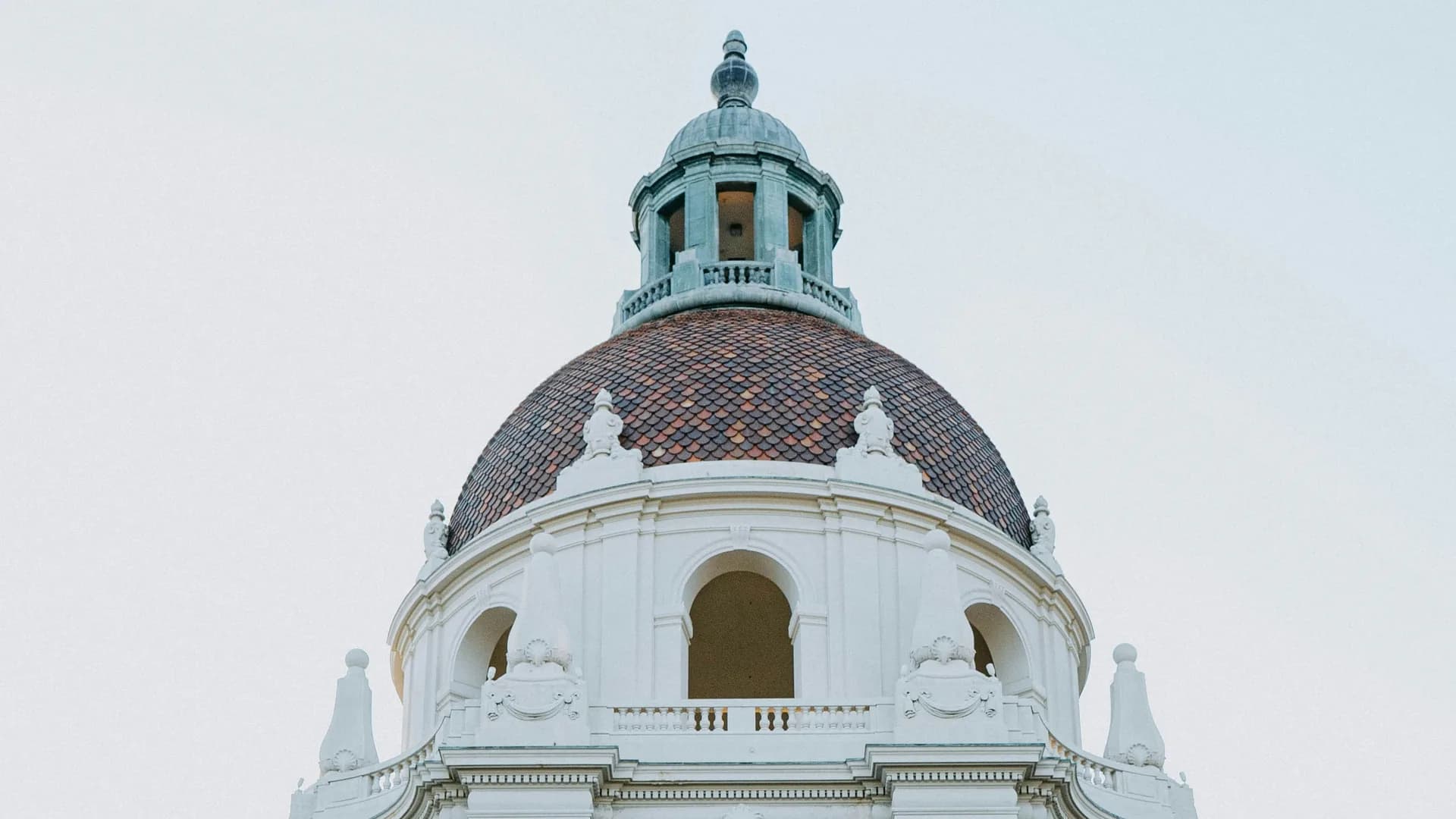 The tiled dome and cupola of Pasadena City Hall above its arched colonnade